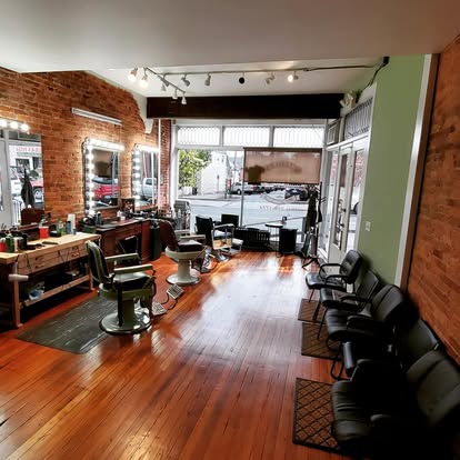 The wood-floor and exposed-brick interior of Masters Barbershop